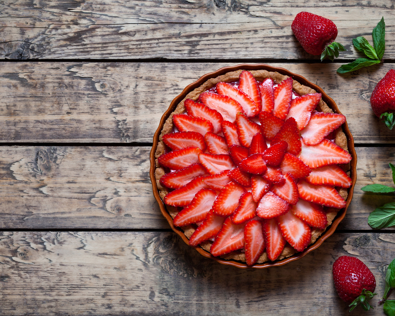 Аппетитный пирог со свежей клубникой на столе 