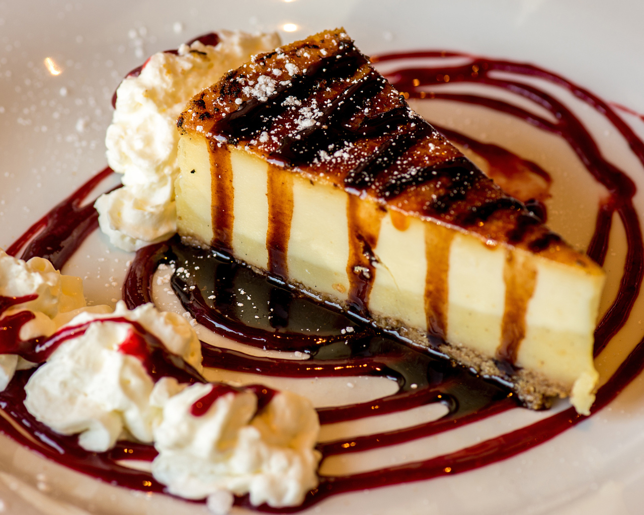 Аппетитный кусок чизкейка со сливками и клубничным джемом