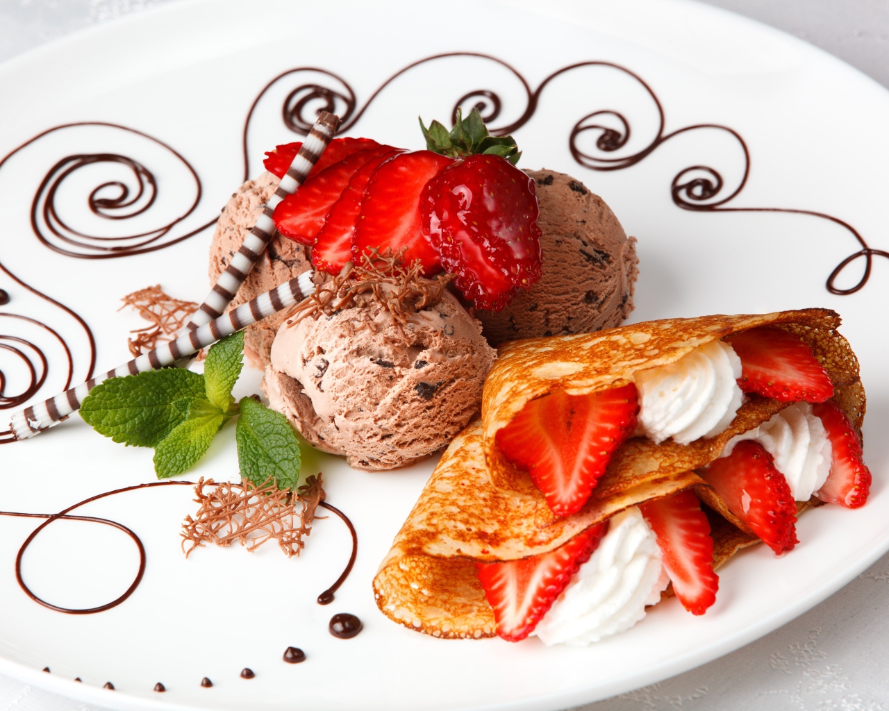 Шарики шоколадного мороженого с аппетитными блинчиками с клубникой