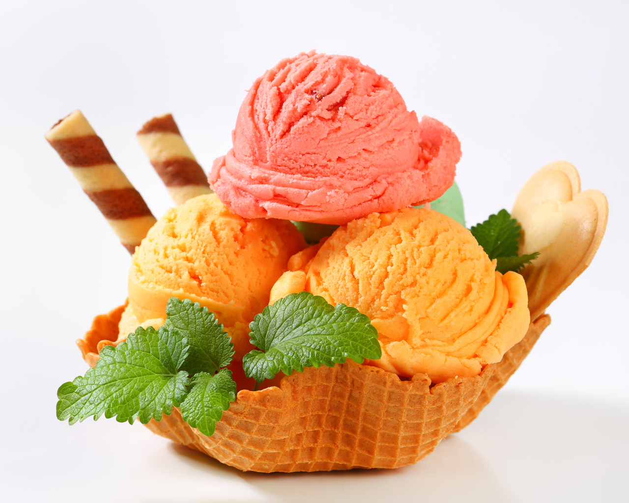 Шарики персикового и малинового мороженого в вафельной корзинке