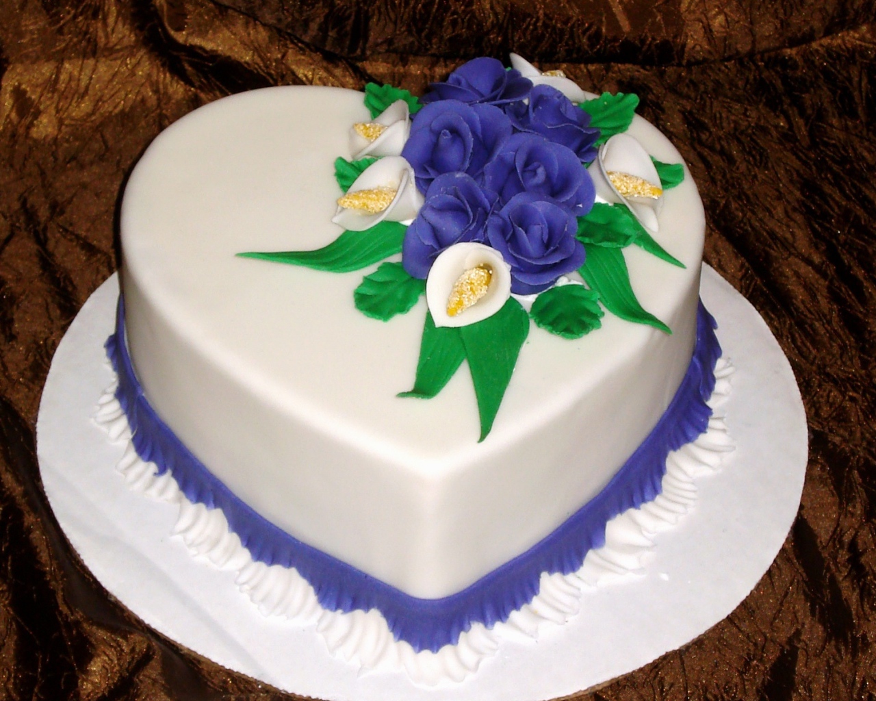 Красивый торт в форме сердца украшен цветами