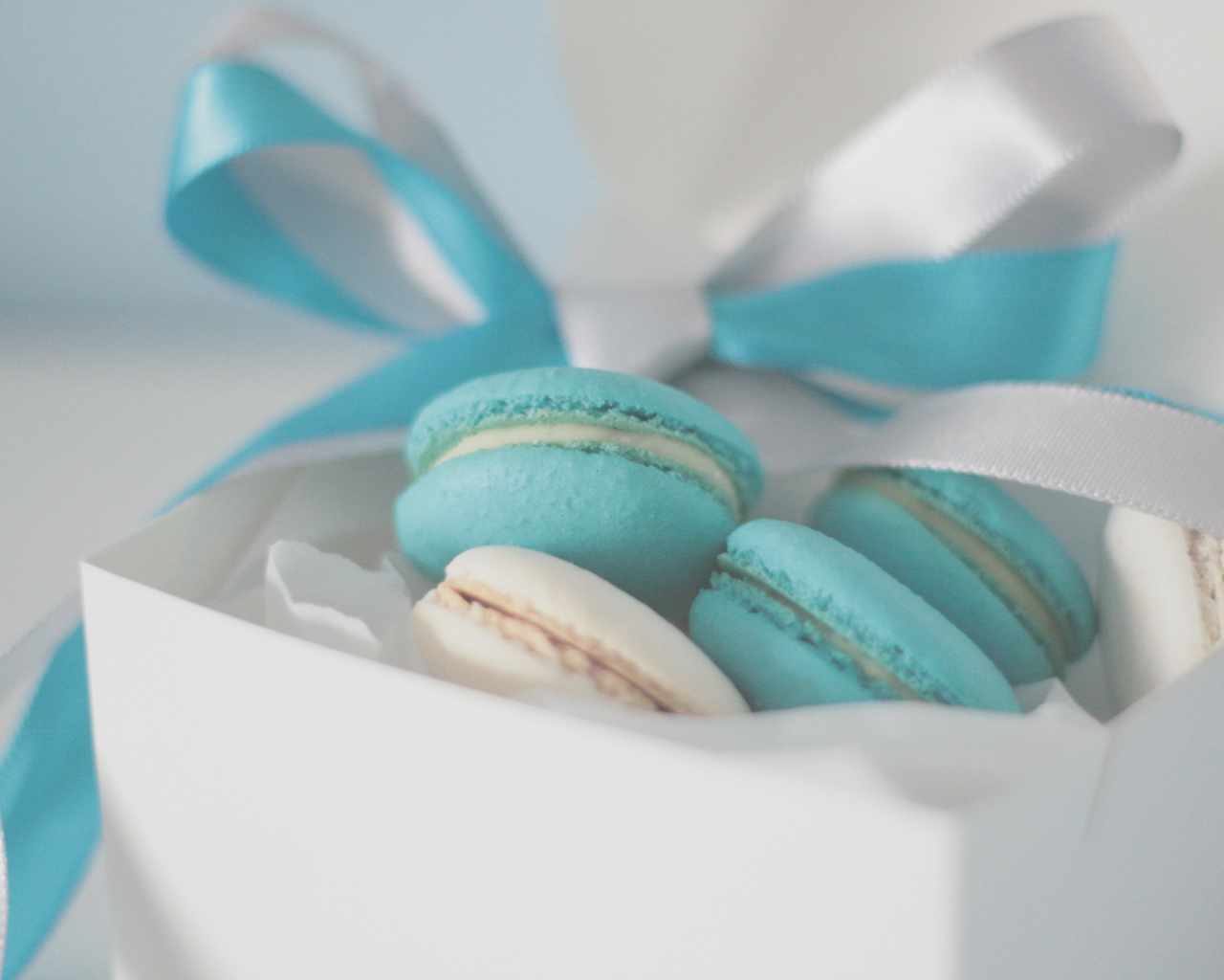 Голубые макаруны в белой коробке с белой и голубой лентой