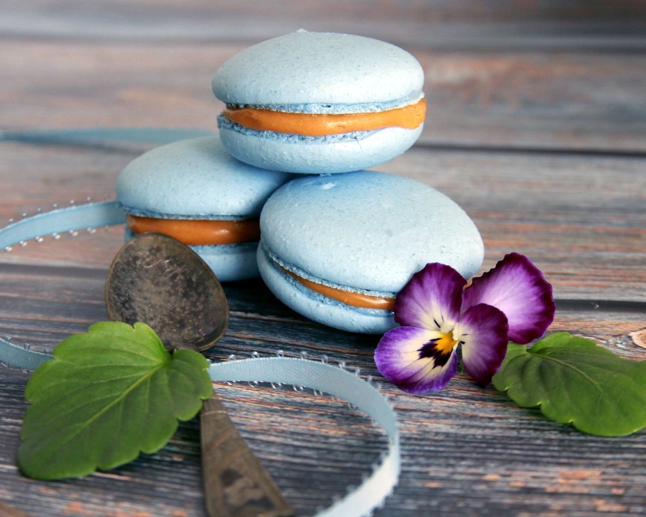Голубые макаруны на столе с цветком 