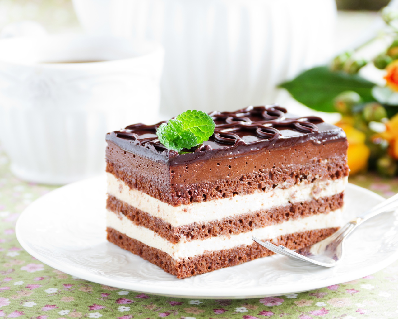 Пирожное с шоколадным и сливочным кремом на белой тарелке