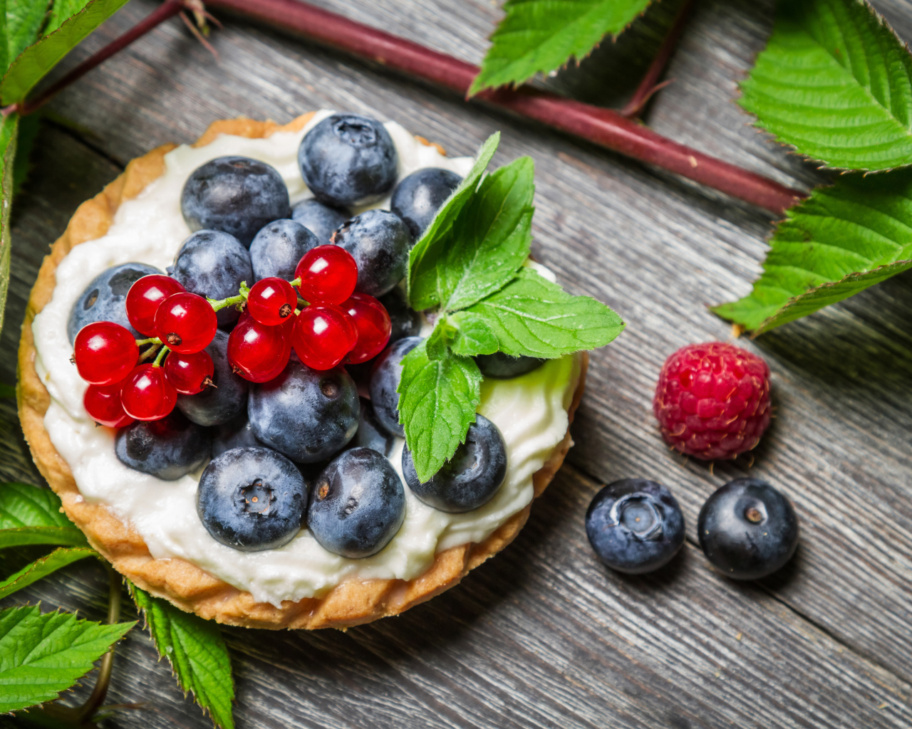 Пирожное со сливками и свежими ягодами смородины, черники и малины