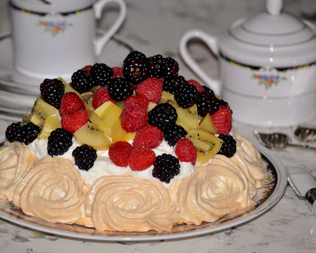 Торт с безе и свежими ягодами на столе 