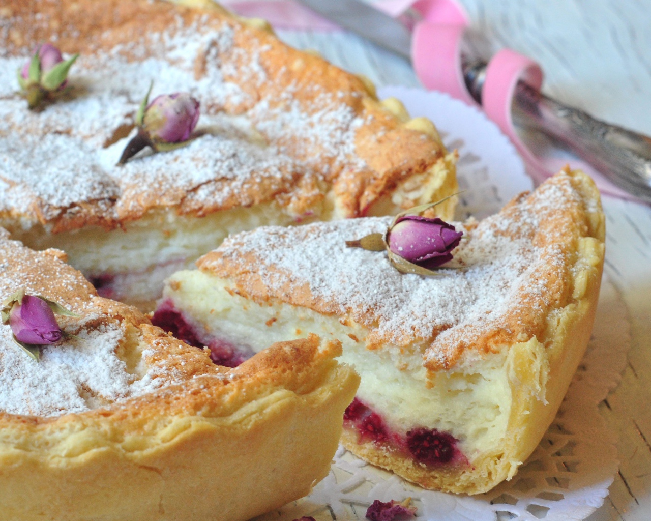 Пирог с суфле и малиной посыпанный сахарной пудрой и цветами