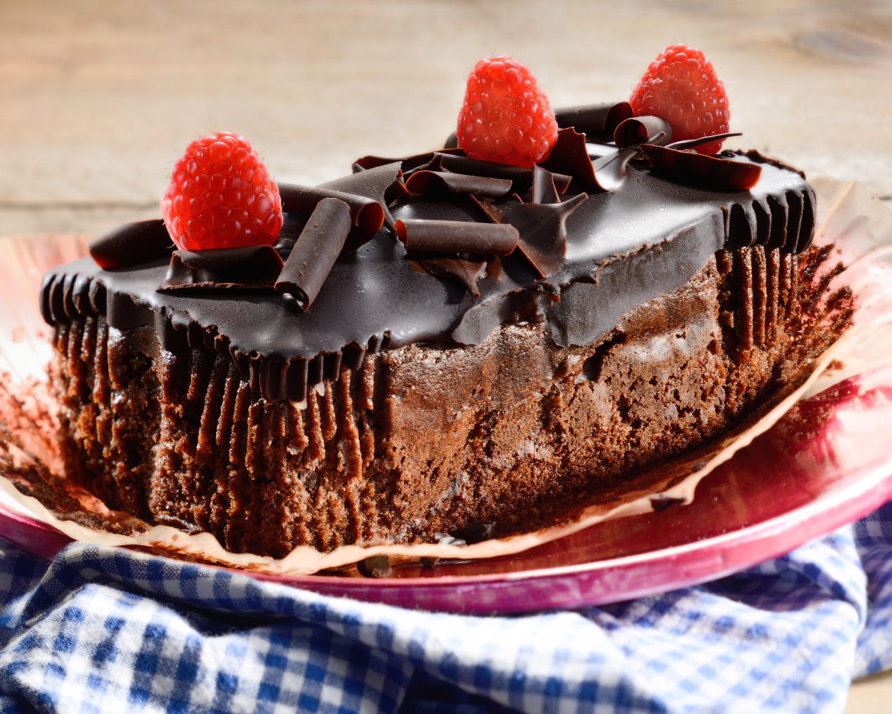 Шоколадное пирожное со свежей малиной на тарелке