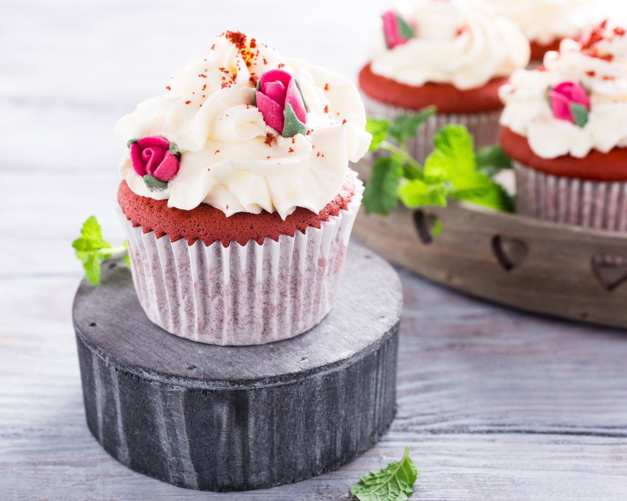 Шоколадный капкейк с кремом и розочками на столе