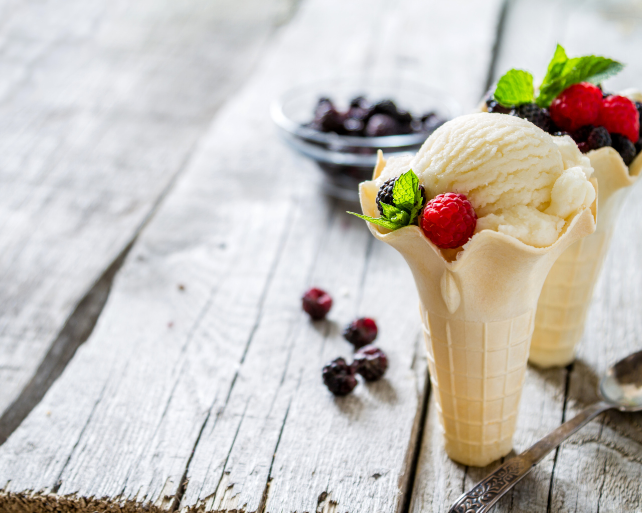 Сливочное мороженое в вафельном стаканчике с ягодами