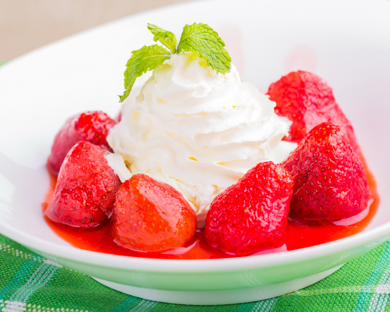 Вкусные сливки с клубникой на белой тарелке