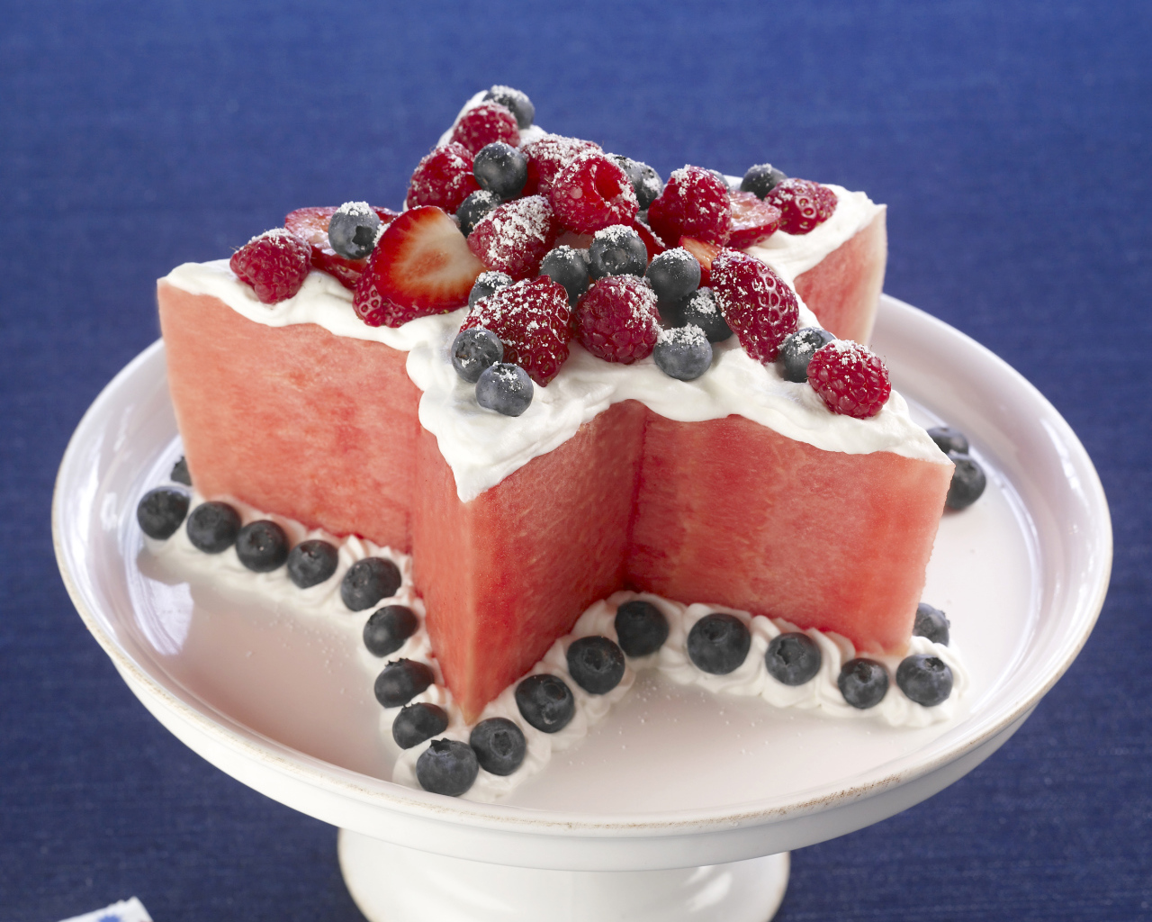 Десерт из арбуза со сливками и ягодами малины, клубники и черники