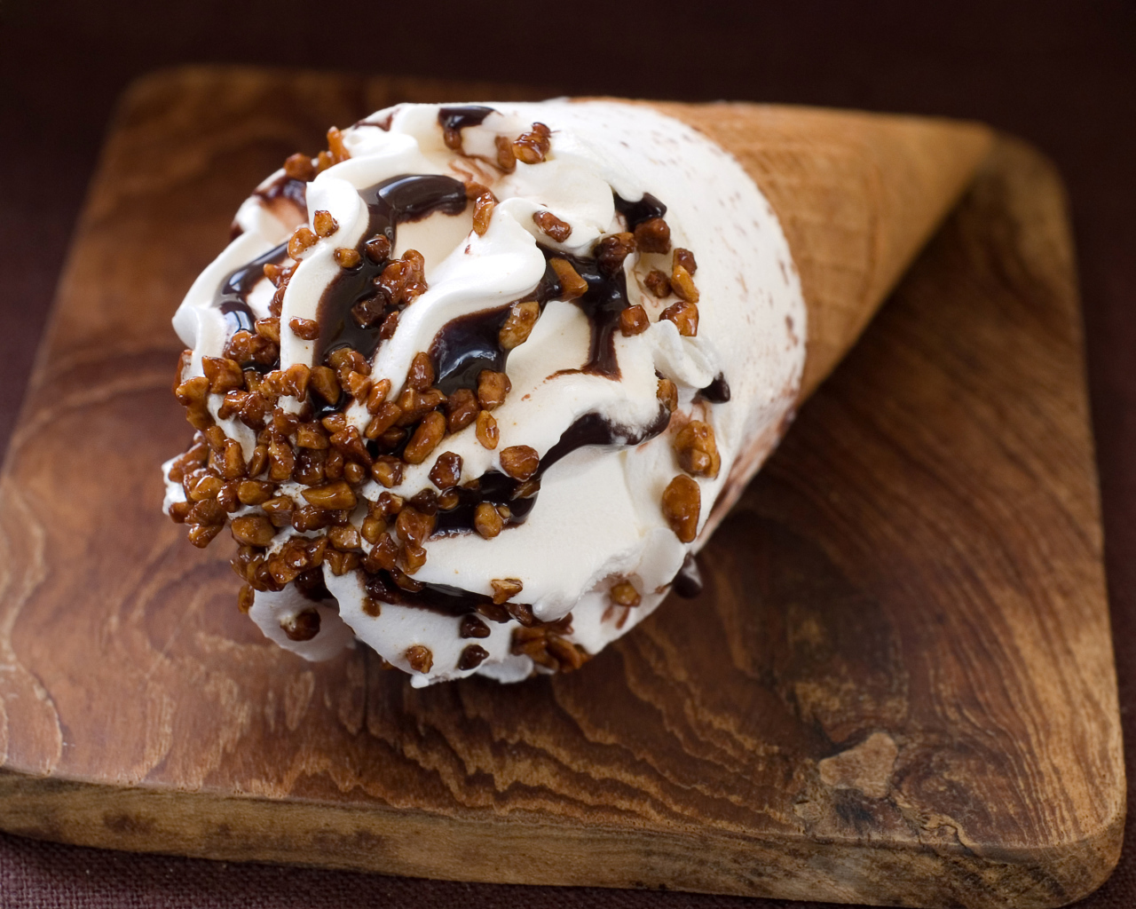 Мороженое рожок с шоколадом на разделочной доске