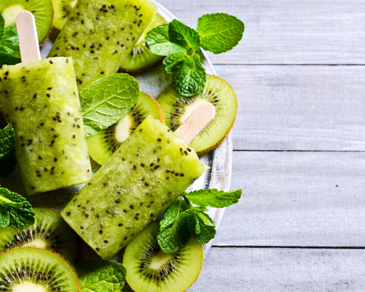 Мороженое с киви и листиками мяты на деревянном столе