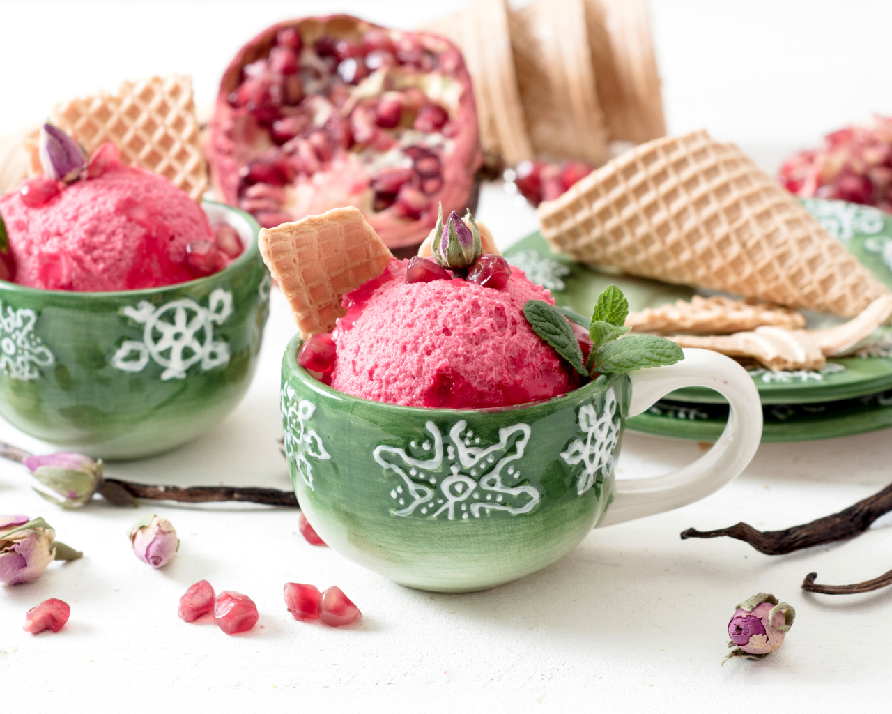 Мороженое с зернами граната в зеленых чашках на столе