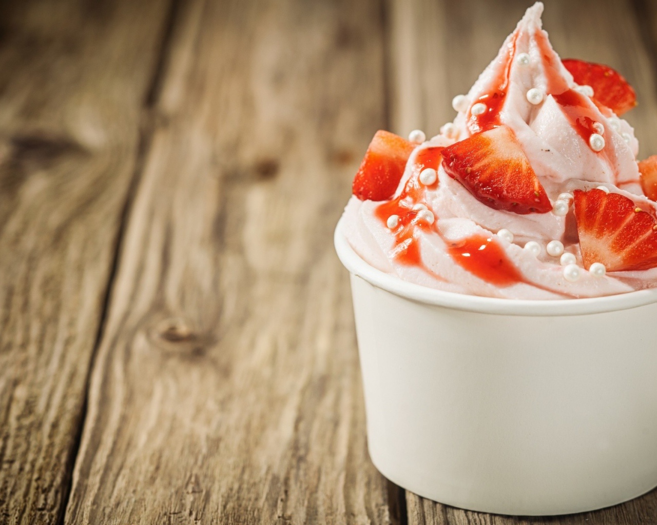 Мороженое с клубникой в белом стакане 