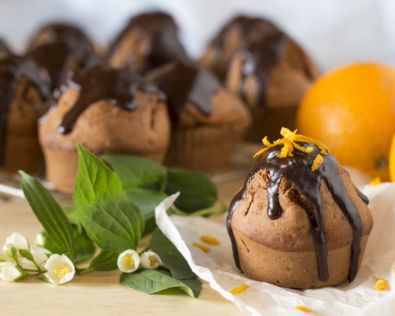 Маффины с шоколадом на столе с белыми цветами жасмина 