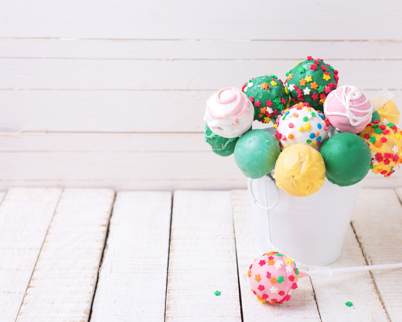 Разноцветные леденцы на палочке в белом ведерке