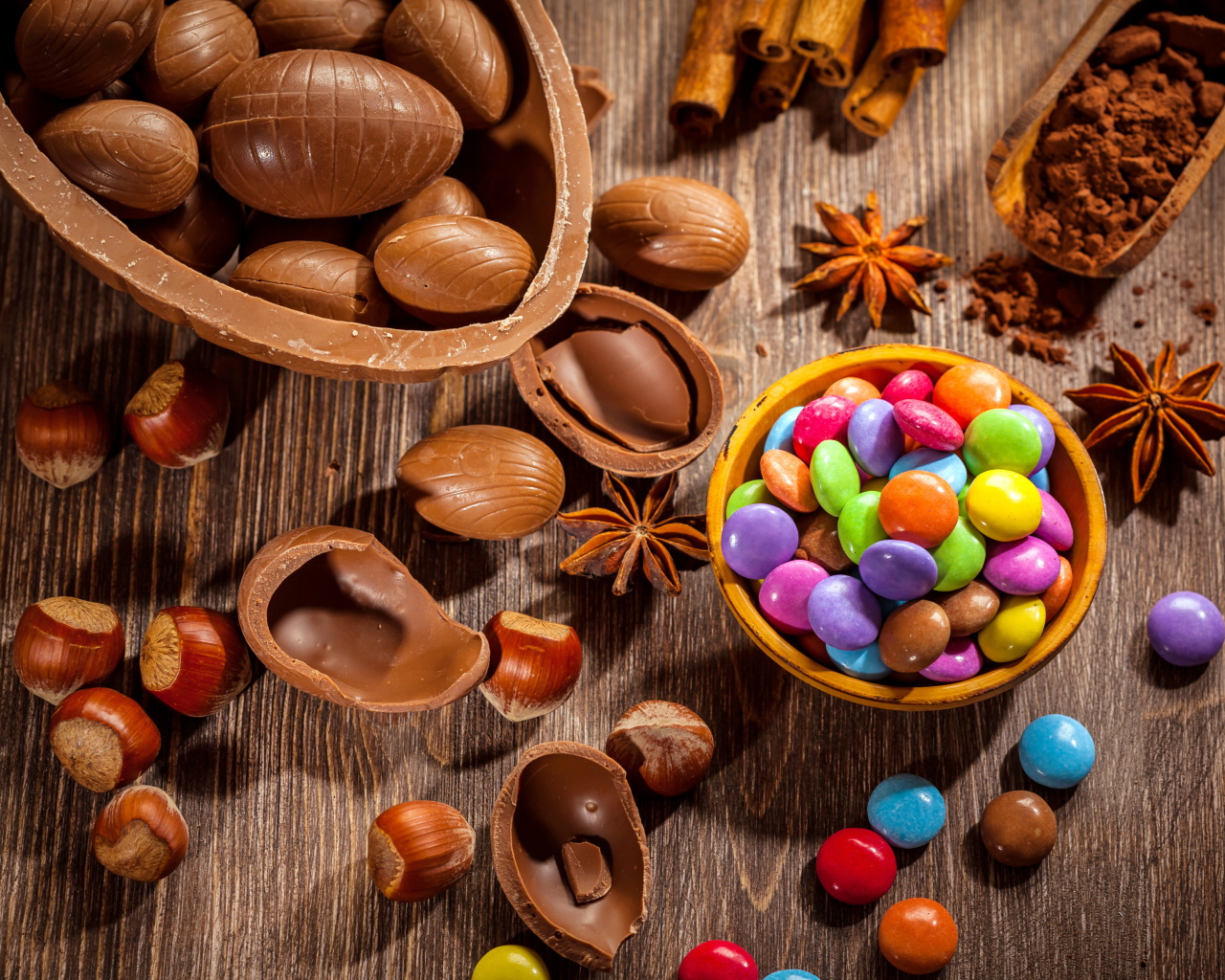 Разноцветные конфеты на столе с шоколадными яйцами и орехами