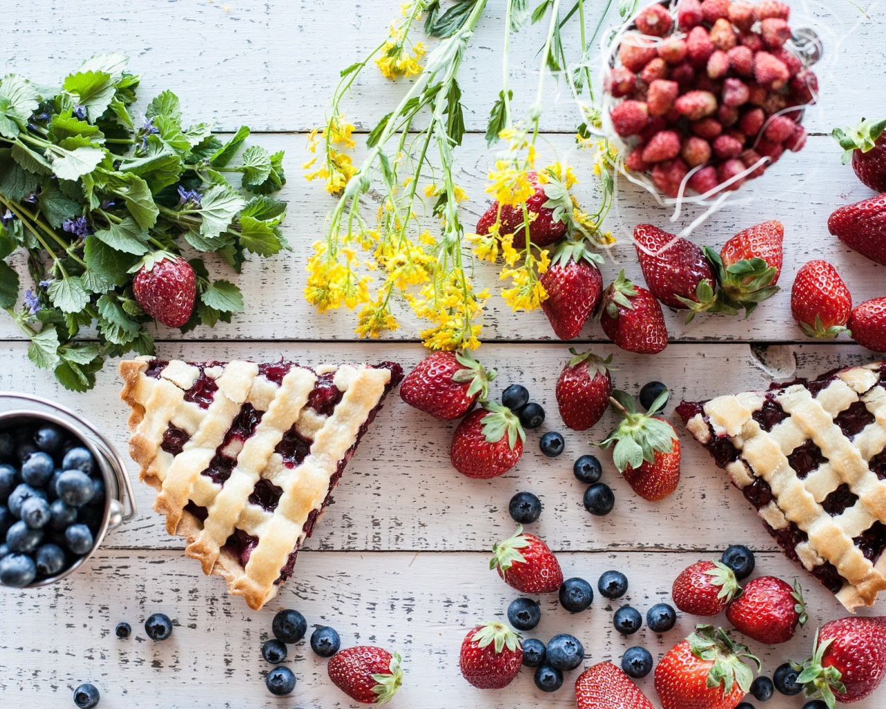 Кусочки пирога на столе с ягодами клубники и черники