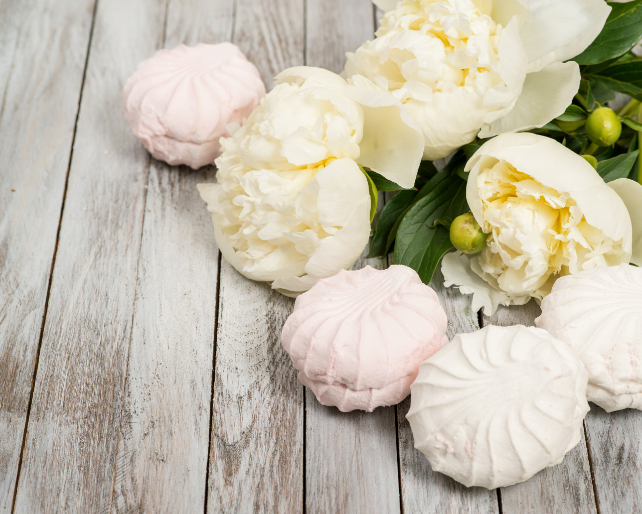 Сладкий зефир на столе с белыми пионами