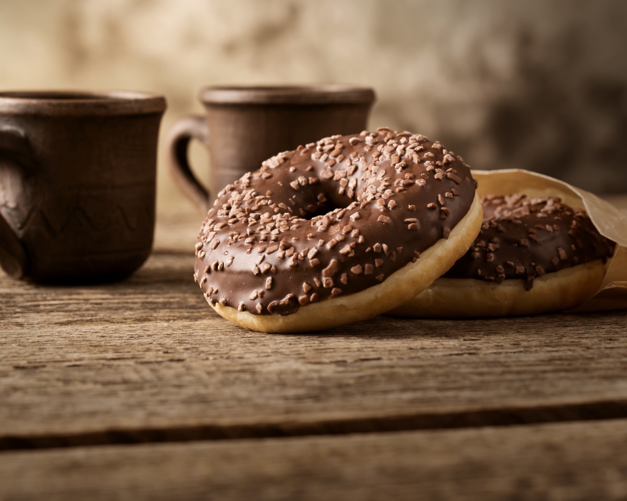 Сладкие круглые пончики с шоколадом на столе 