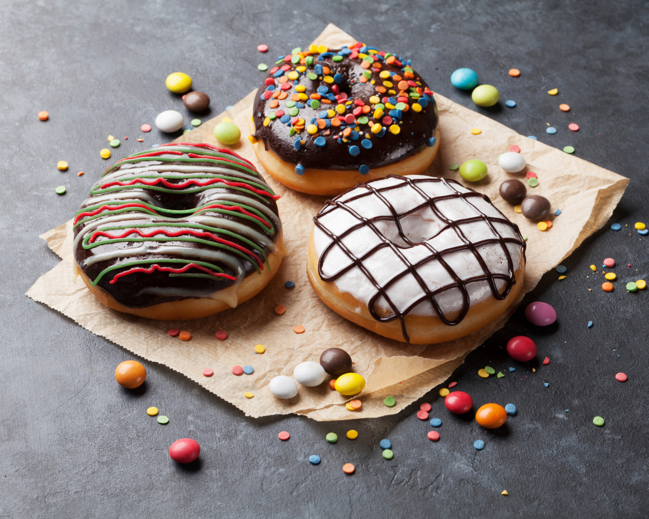 Три аппетитных сладких пончика с конфетами 