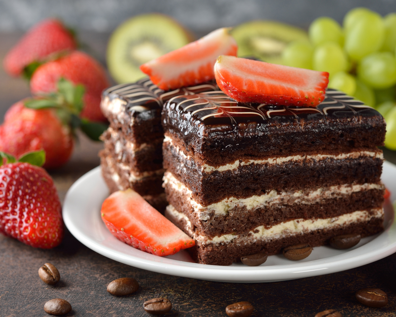 Два кусочка шоколадного пирожного с ягодами клубники