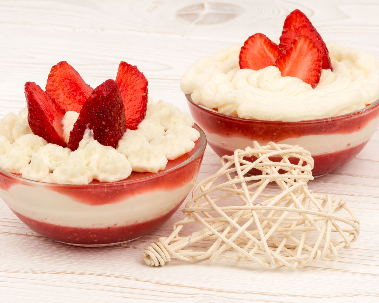 Две тарелки сладкого десерта со сливками и клубникой