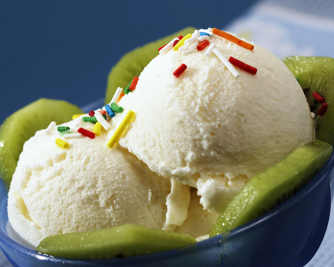 Ванильное мороженое с кусочками киви в синей тарелке