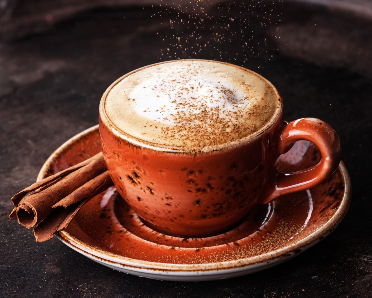 Чашка капучино с корицей на блюдце