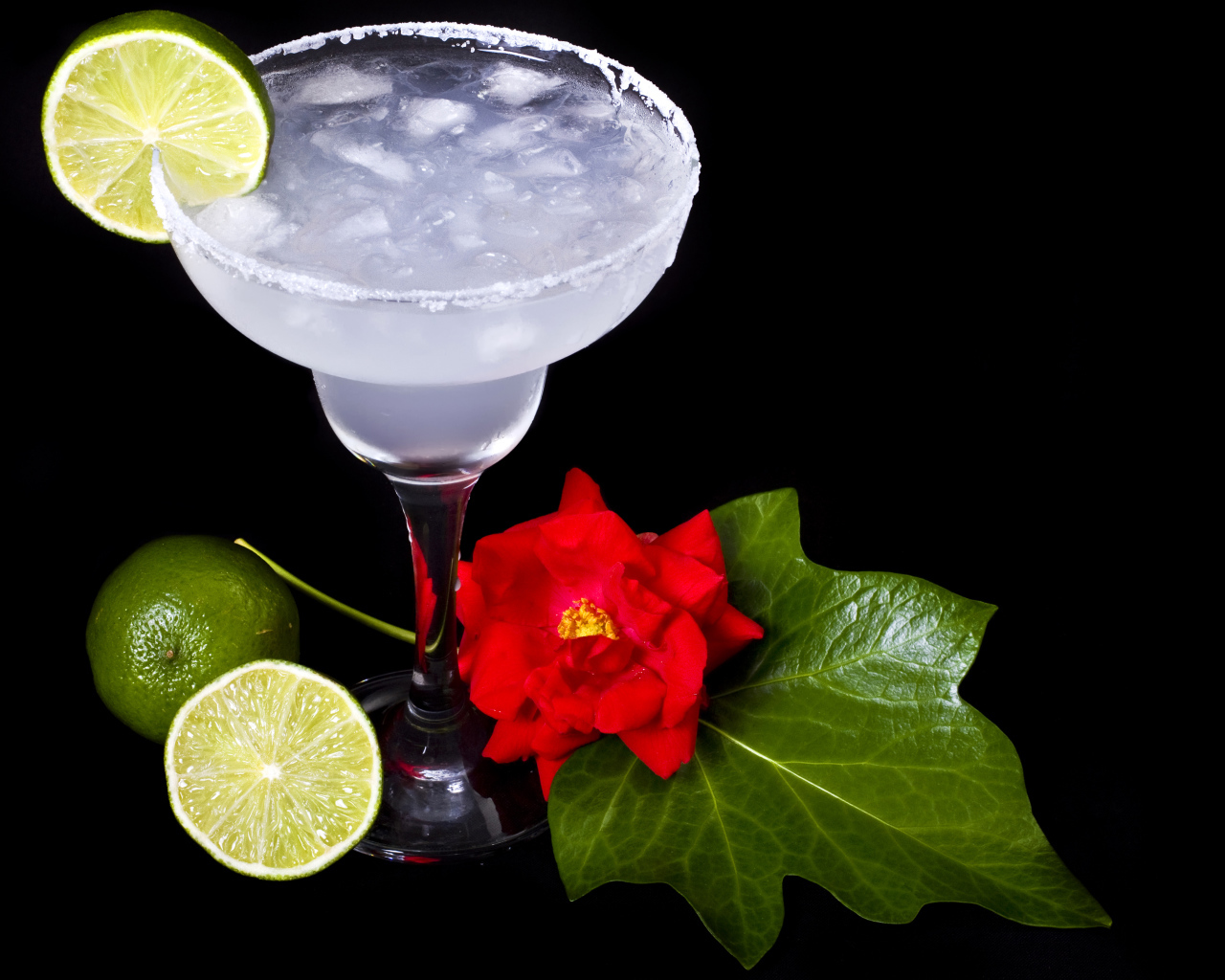 Бокал коктейля со льдом и лаймом на черном фоне