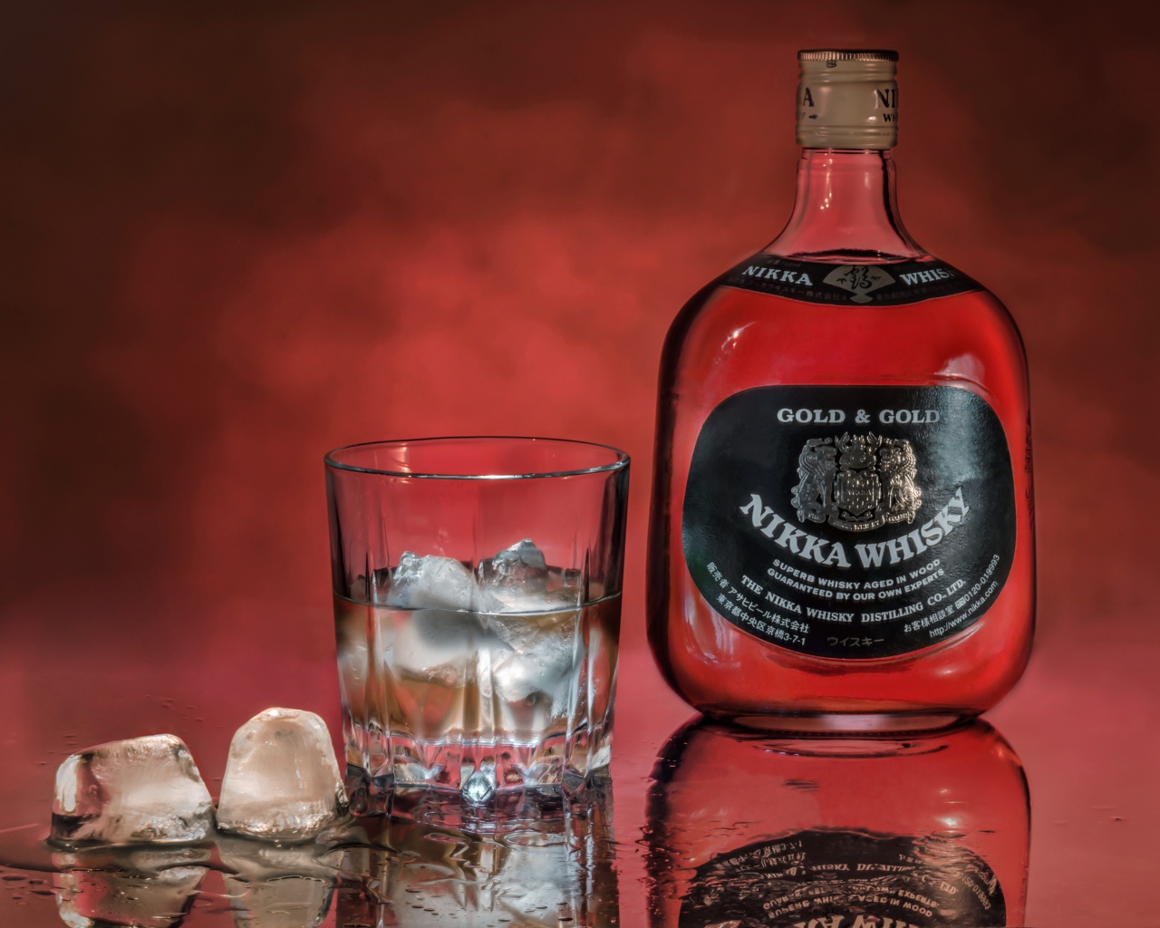 Бутылка Nikka Whisky на столе со стаканом со льдом