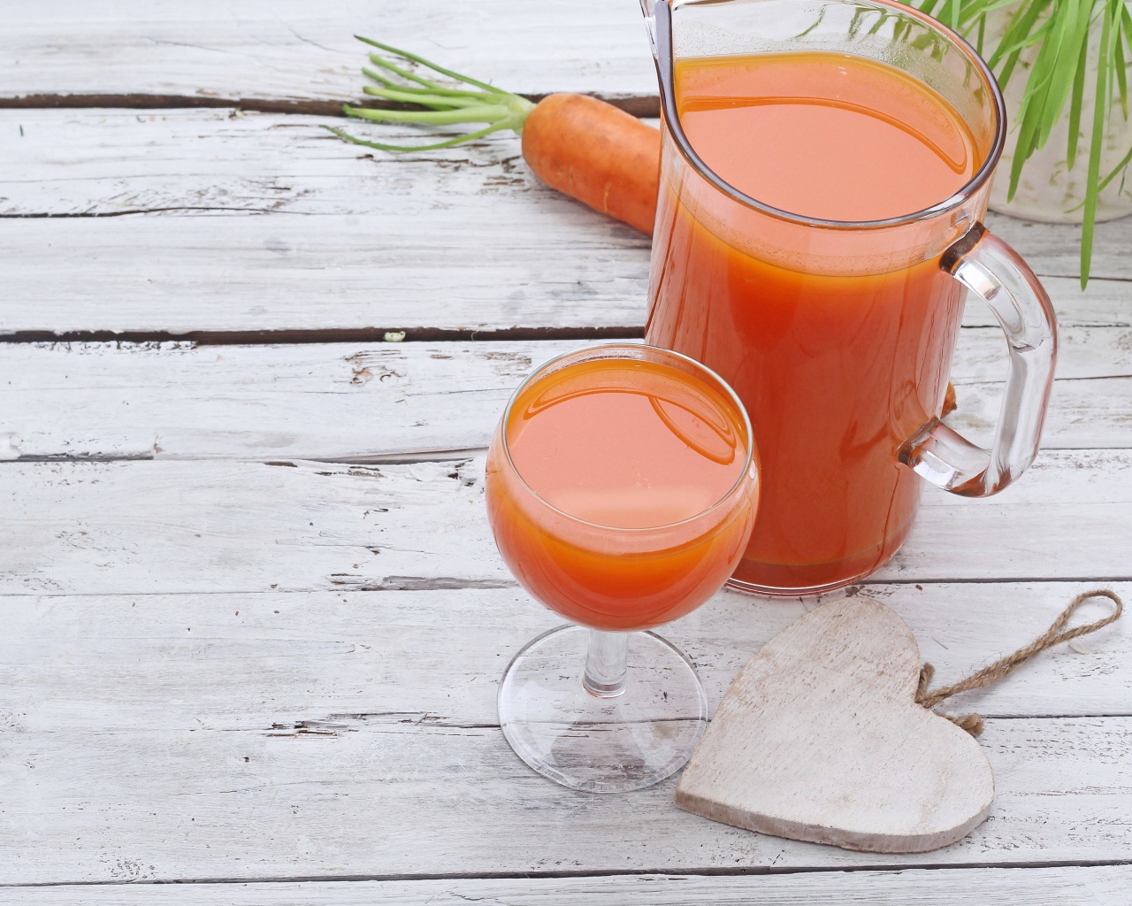 Морковный сок в кувшине на столе с  бокалом