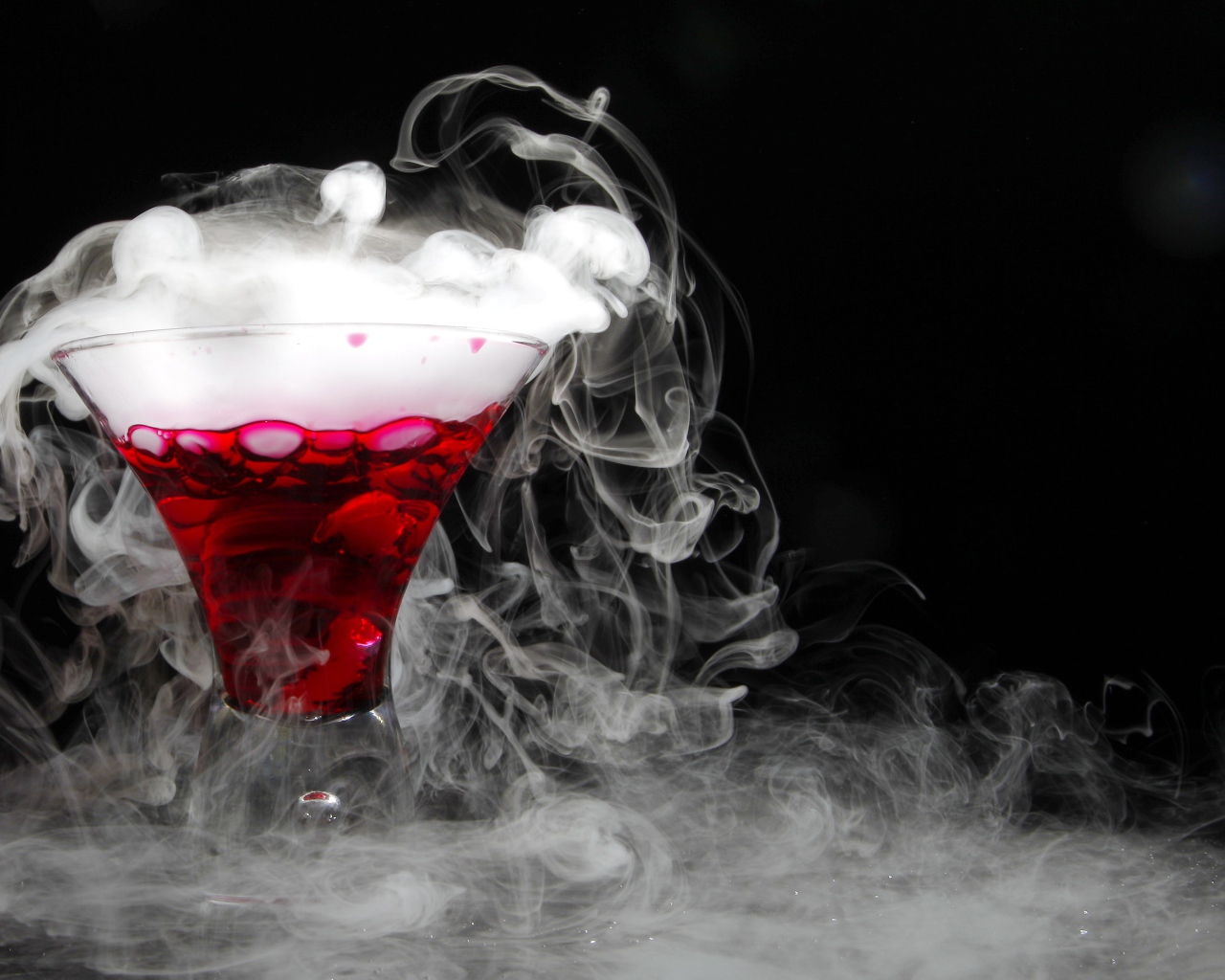 Коктейль с сухим льдом на черном фоне