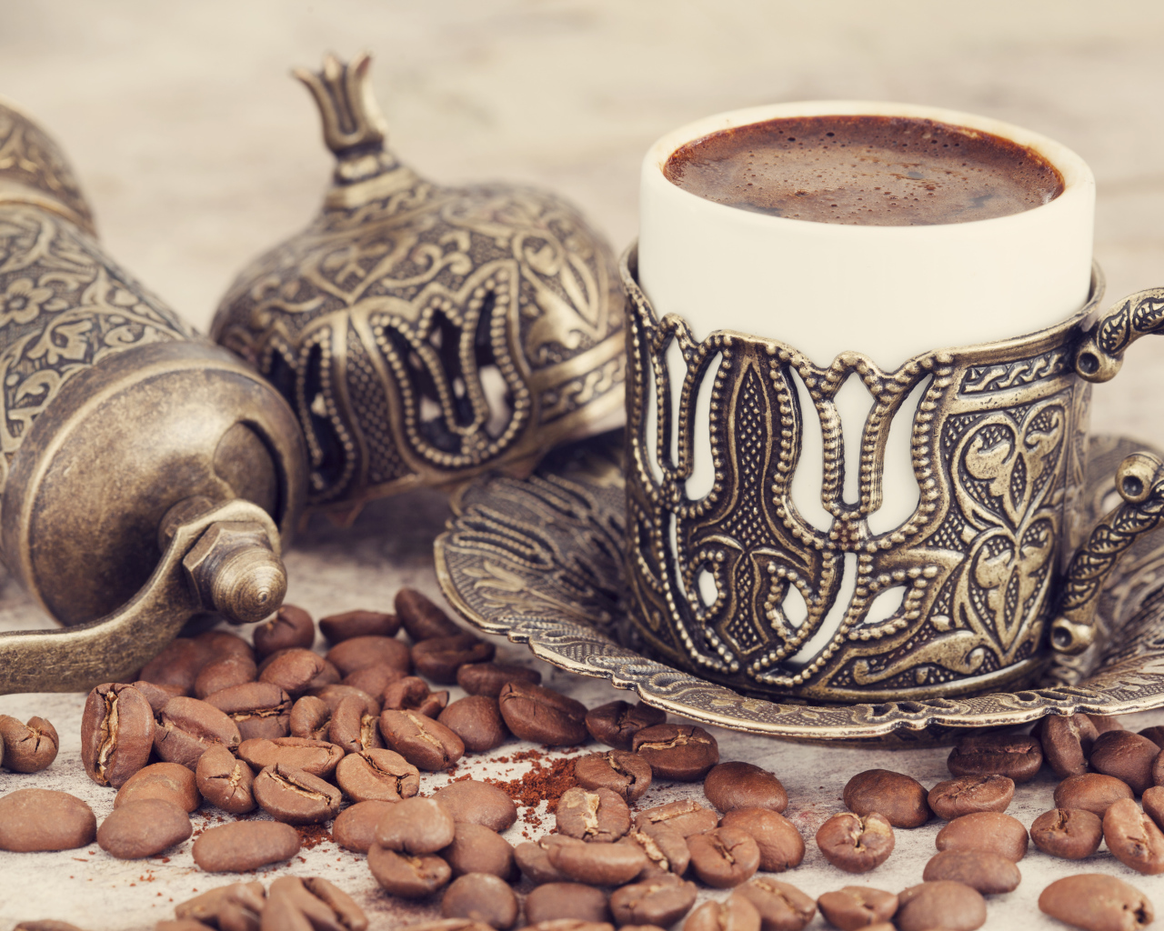 Вкусный кофе в красивой чашке с кофейными зернами на столе