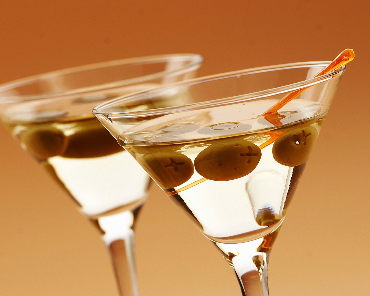 Напиток мартини в бокалах с оливками на кремовом фоне