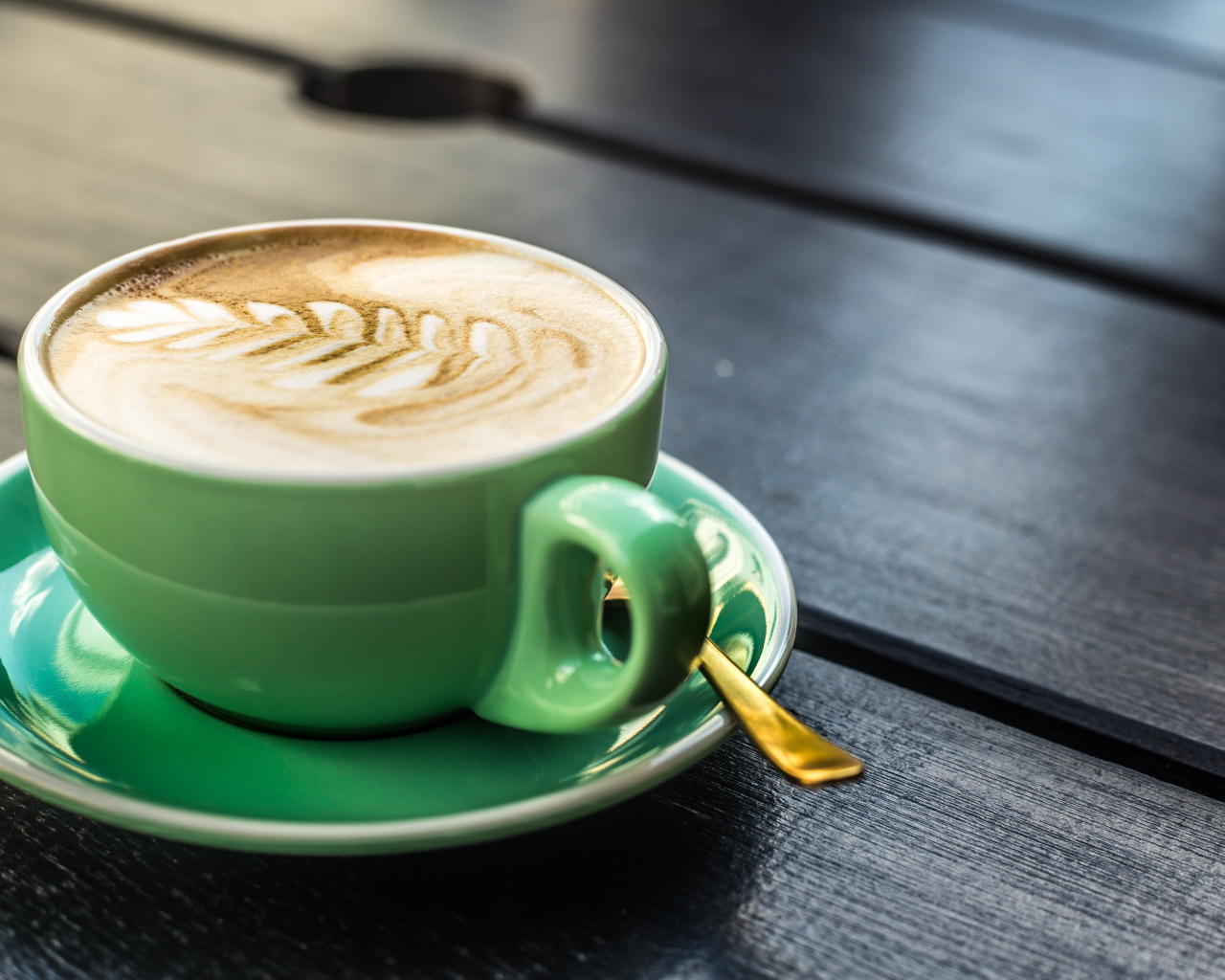 Зеленая чашка капучино с белой пенкой 
