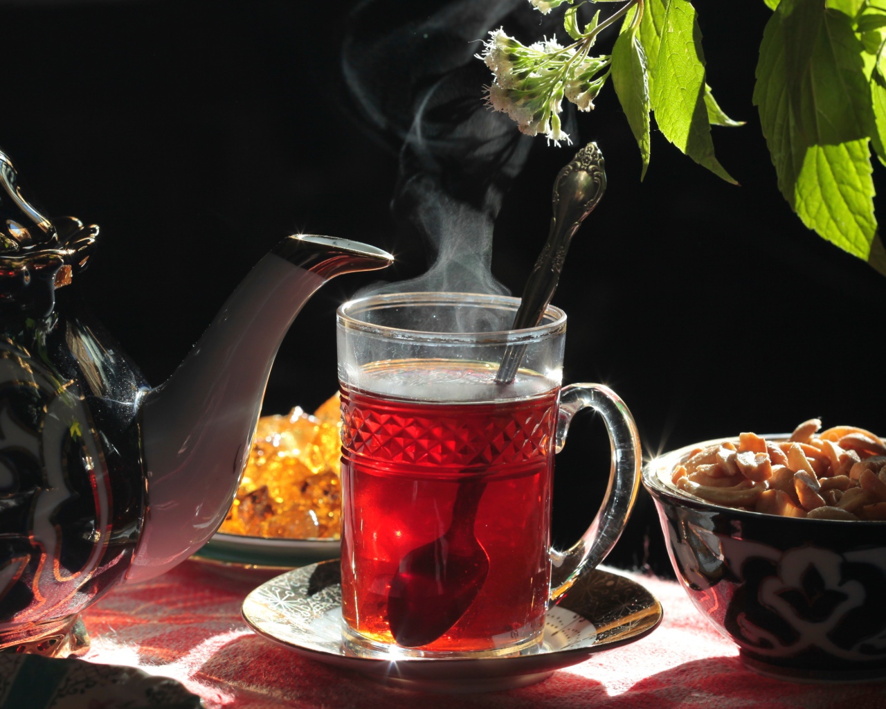 Горячий чай в стеклянной чашке на столе