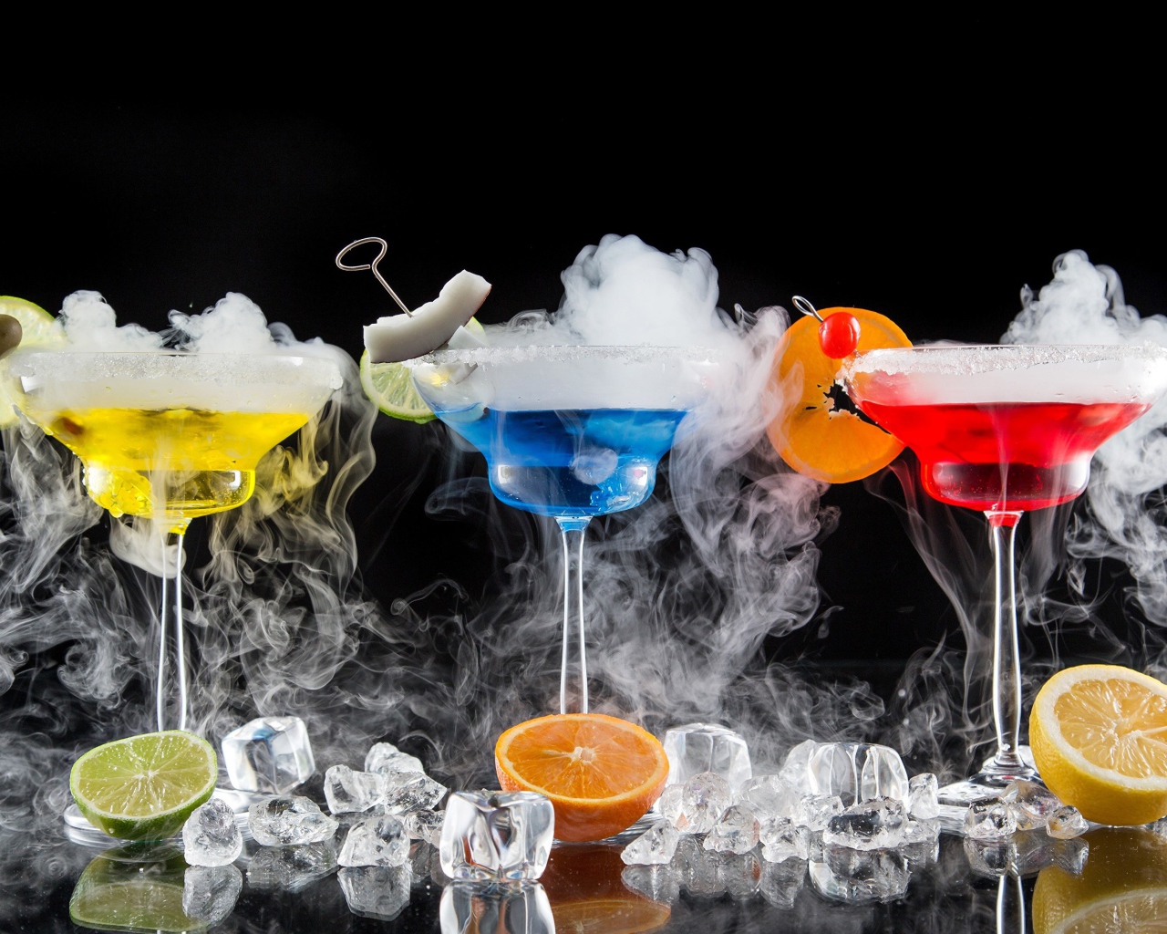 Три алкогольных коктейля с сухим льдом на черном фоне