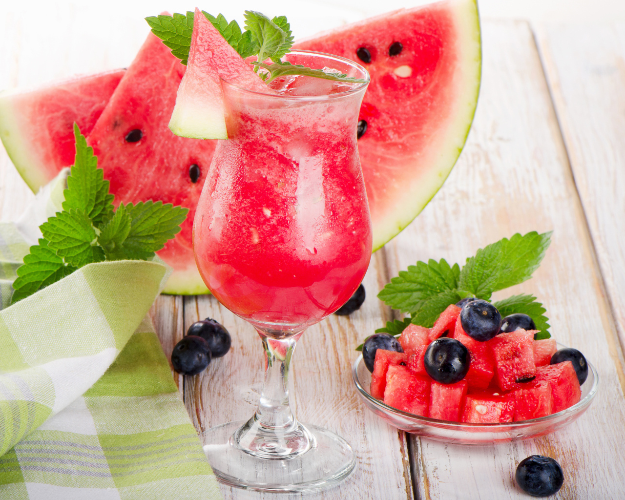 Арбузный сок со льдом в бокале со свежим арбузом и ягодами черники