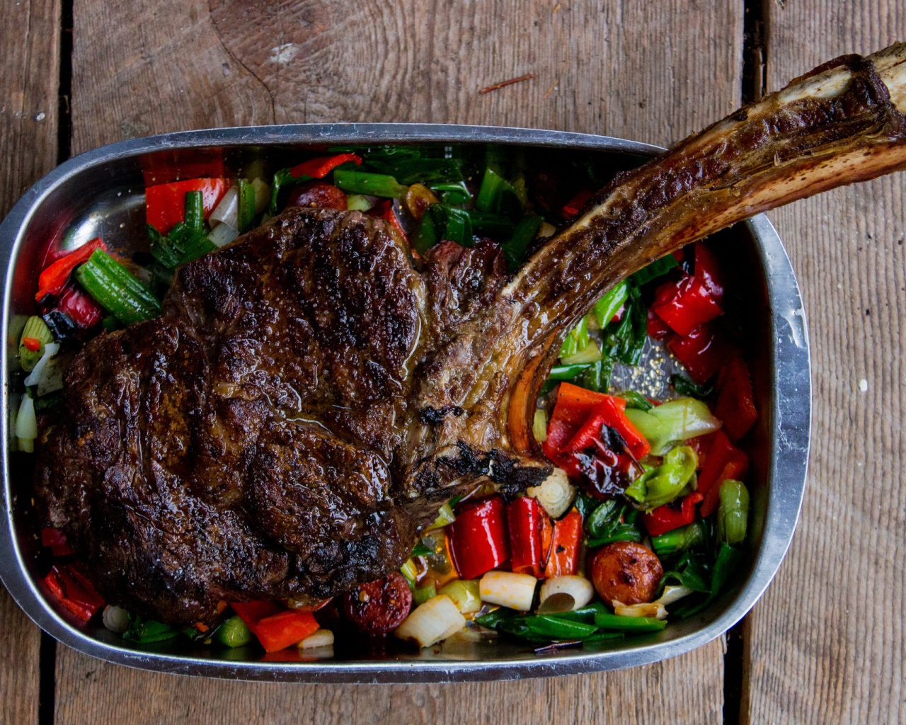 Кусок жареного мяса на ребрышке с овощами