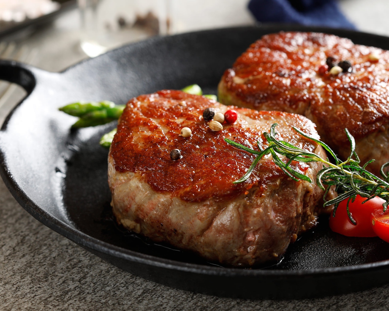 Два аппетитных сочных куска мяса с помидорами и розмарином