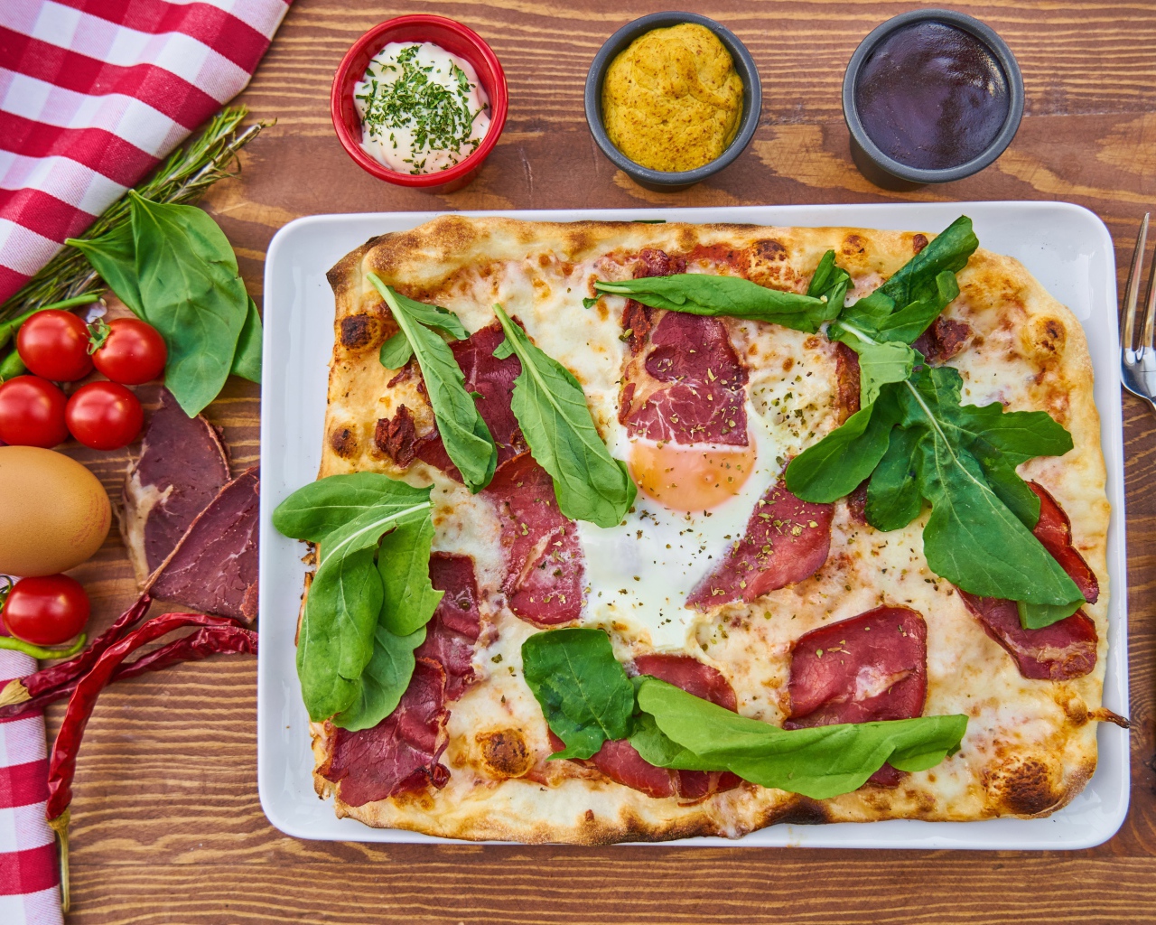 Пицца с беконом и зелеными листьями базилика на столе 