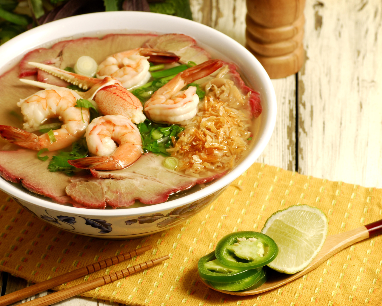 Тарелка супа с креветками и морепродуктами на столе