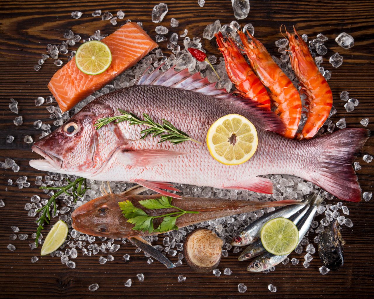 Свежая рыба с креветками и кусочками лимона лежит на кусочках льда