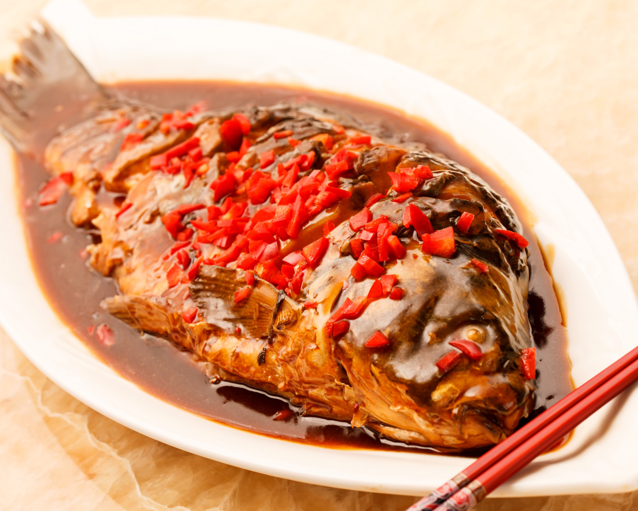 Жареная рыба с соусом и красным перцем в белом блюде