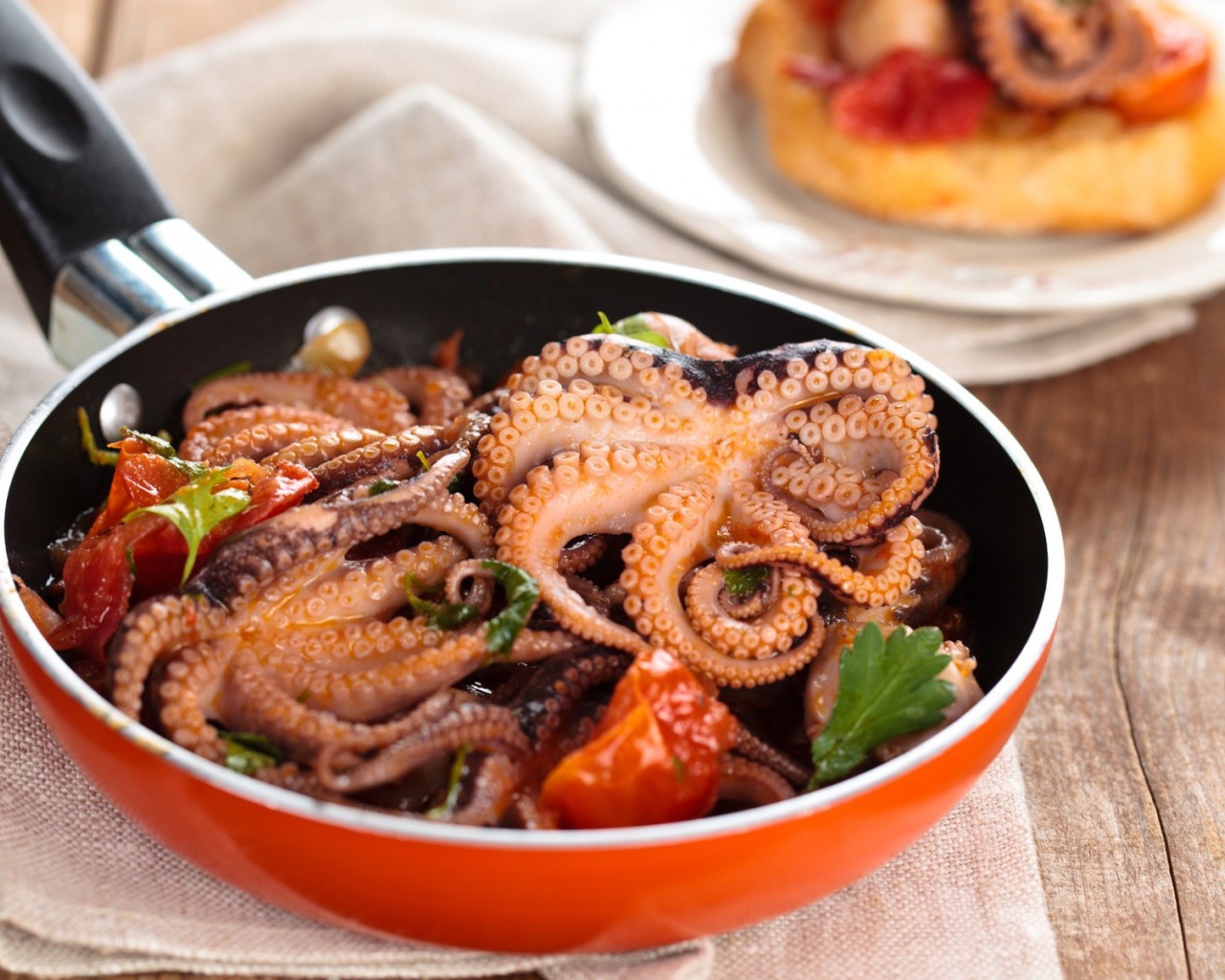 Осьминоги в сковороде на столе 