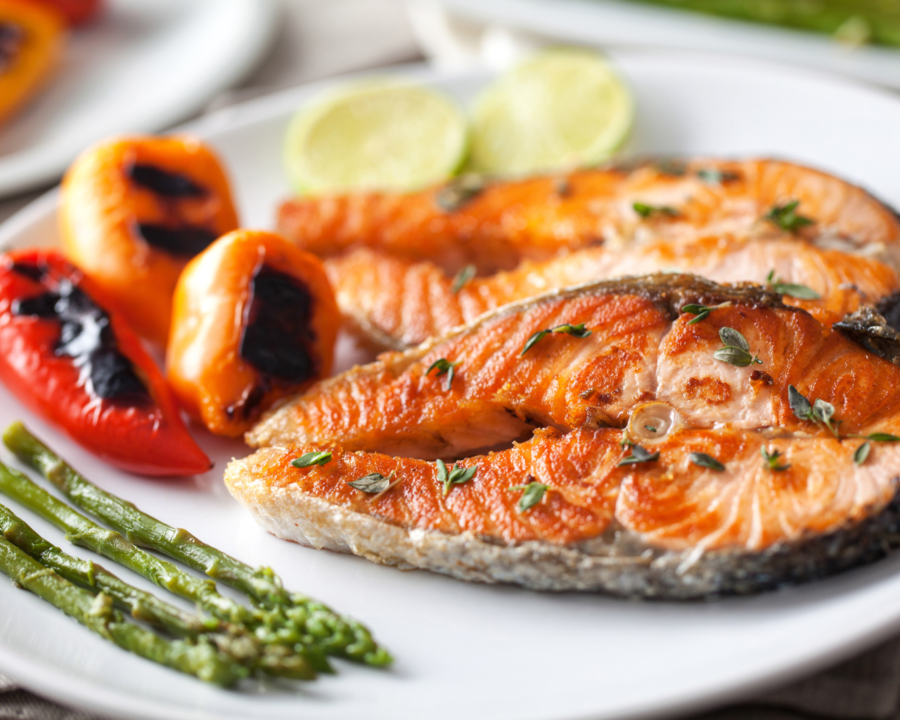 Два кусочка жареной красной рыбы с овощами 