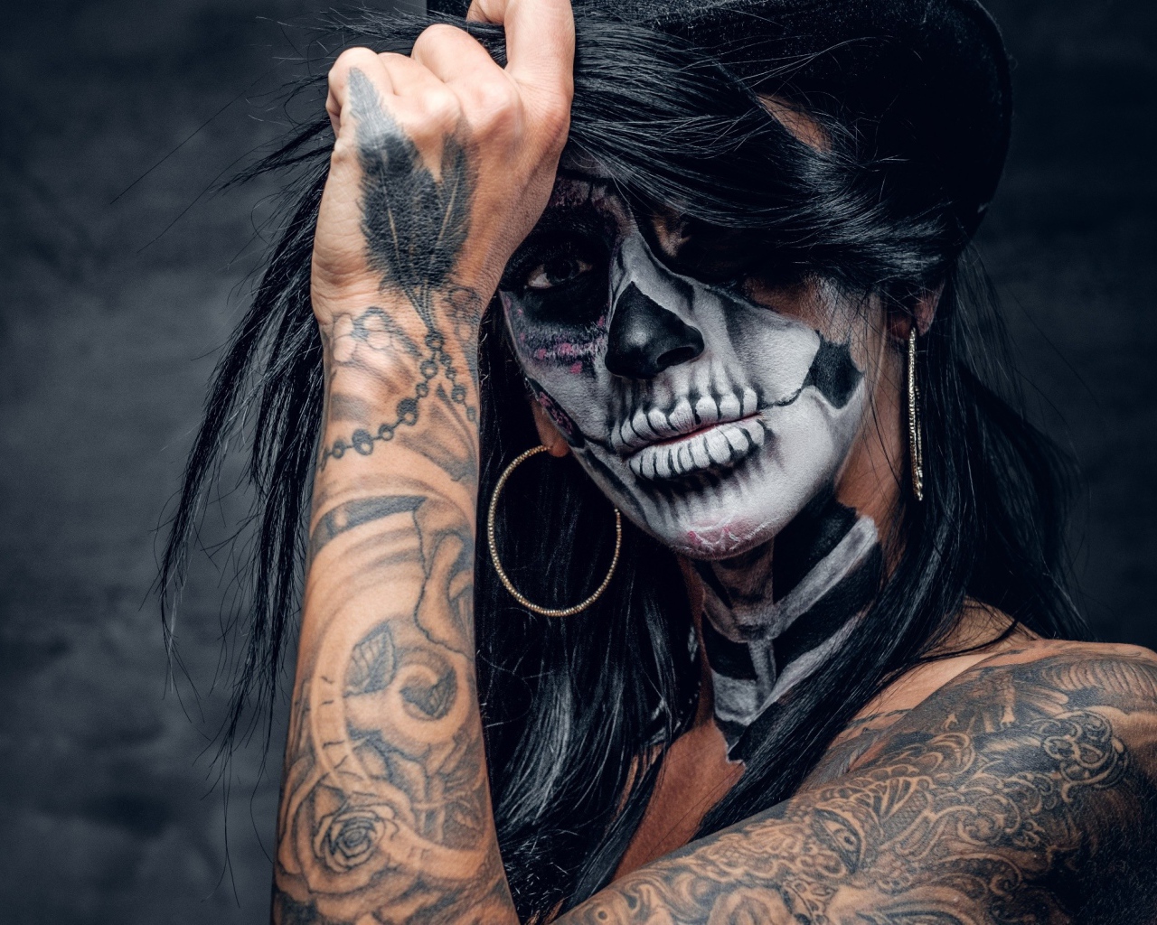 Брюнетка с татуировками и мейкапом на лице 